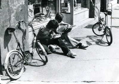 Reading on the pavement outside Kompas, Queen Mary Boulevard, Novi Sad, late 1970s